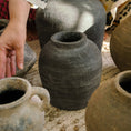 Load image into Gallery viewer, Handmade clay pots on a textured surface with a person's hand reaching towards one of them.