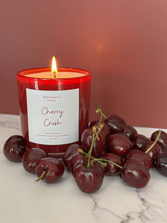 Candle labeled 'Cherry Crush' with cherries on a marble surface